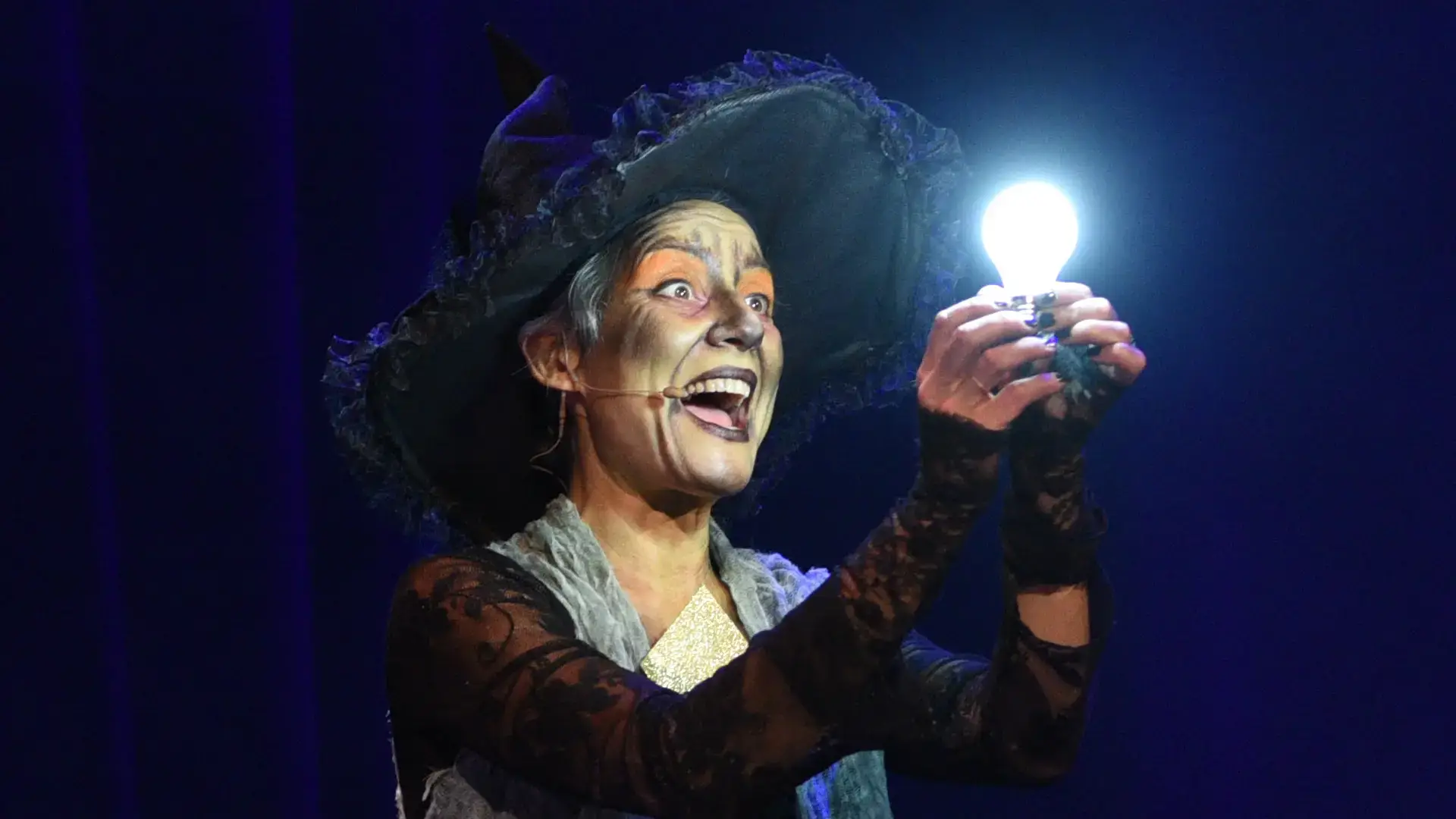 La sorcière du Bal des Fantômes fait apparaître une ampoule magique, spectacle de magie d'Halloween à Lyon