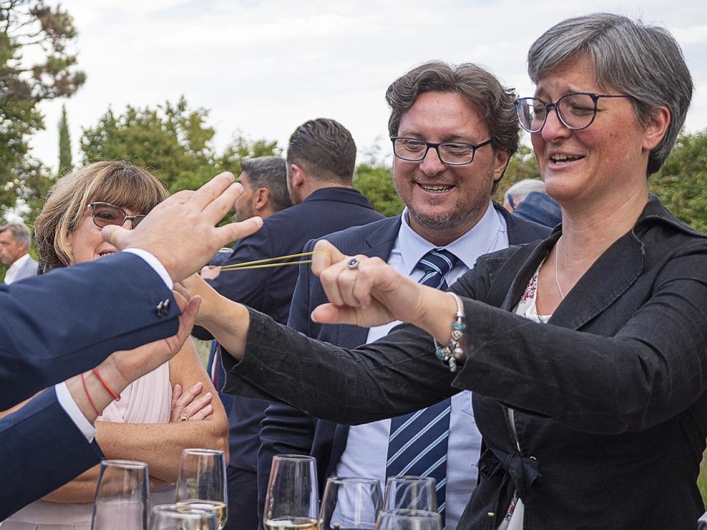 Anthony James en close-up auprès des invités pendant le vin d'honneur, en extérieur