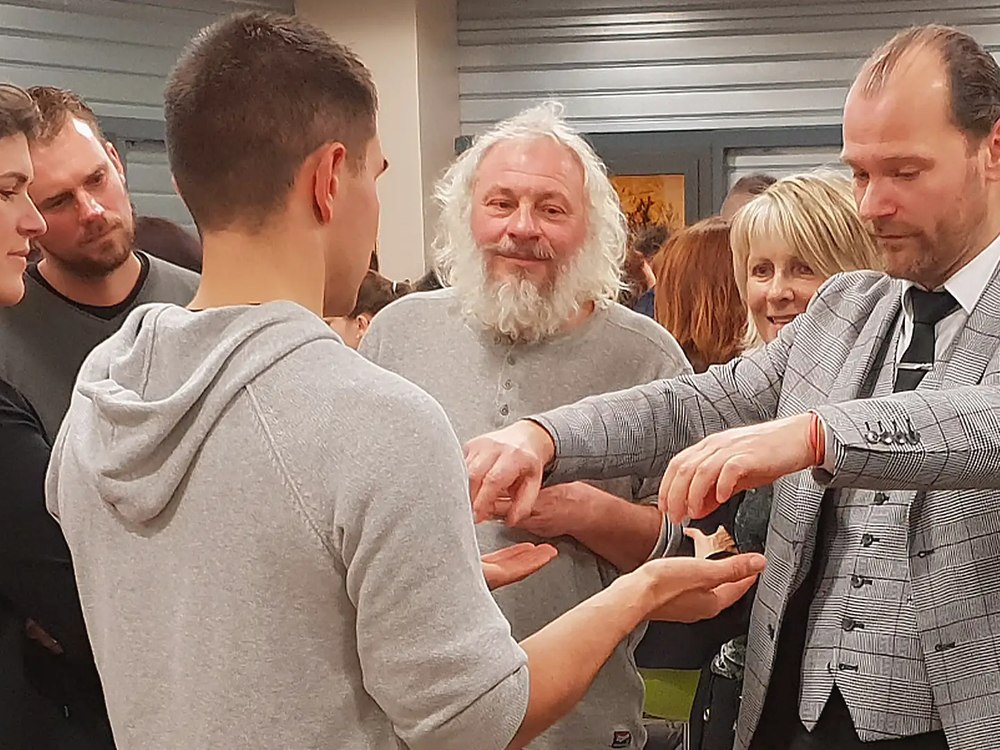 Anthony James en magie de proximité auprès d'un groupe lors d'une soirée conviviale