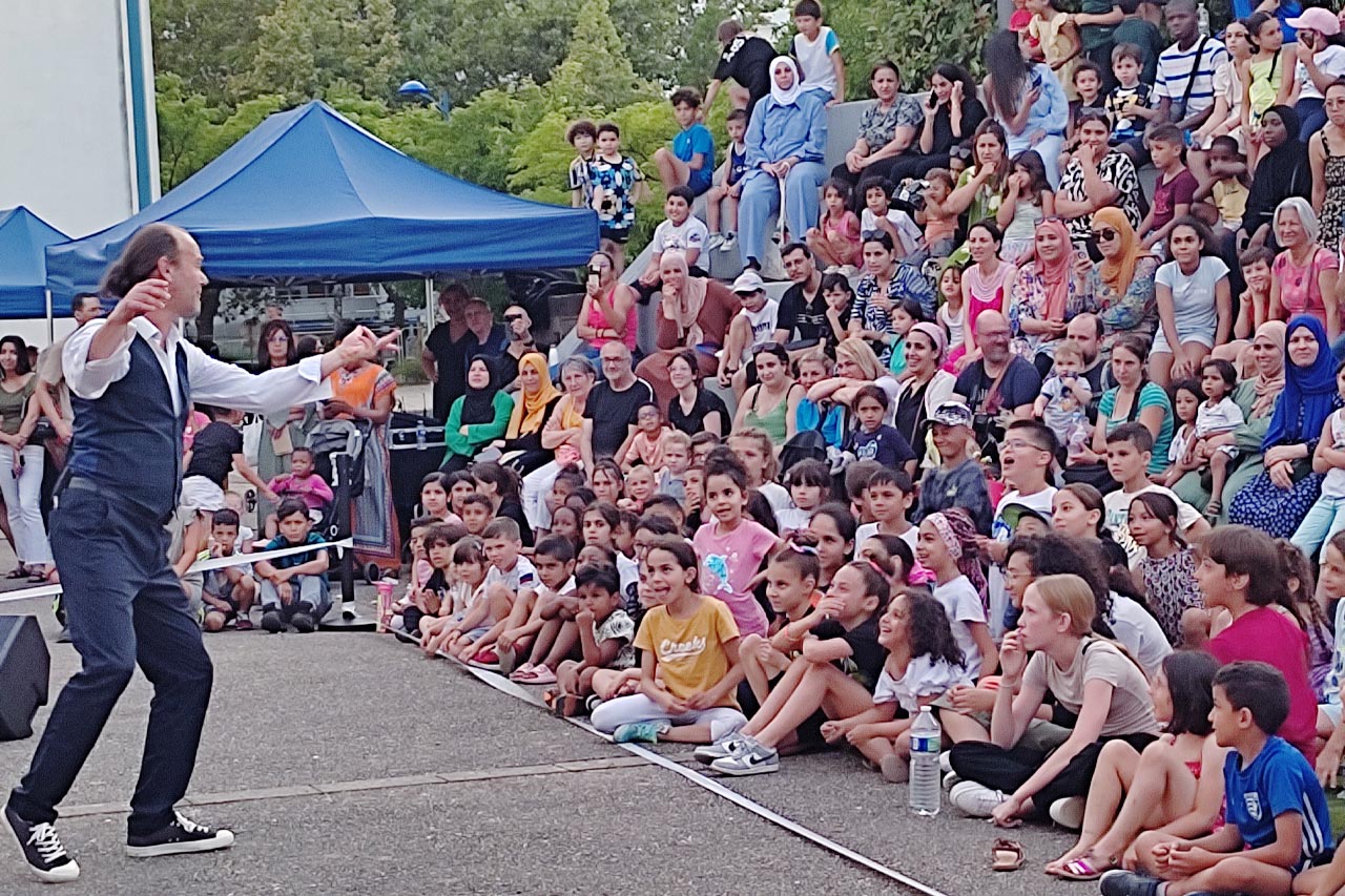 Magie de rue jouée devant un public debout en festival