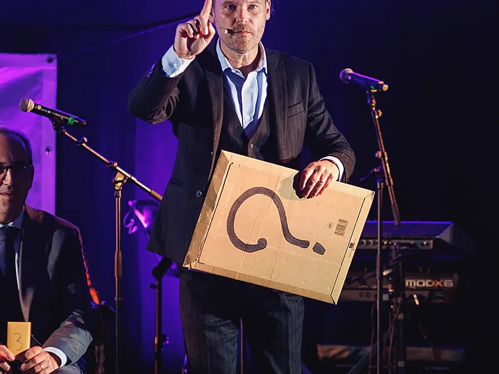 Anthony James présentant une boîte mystère lors d'un spectacle de mentalisme